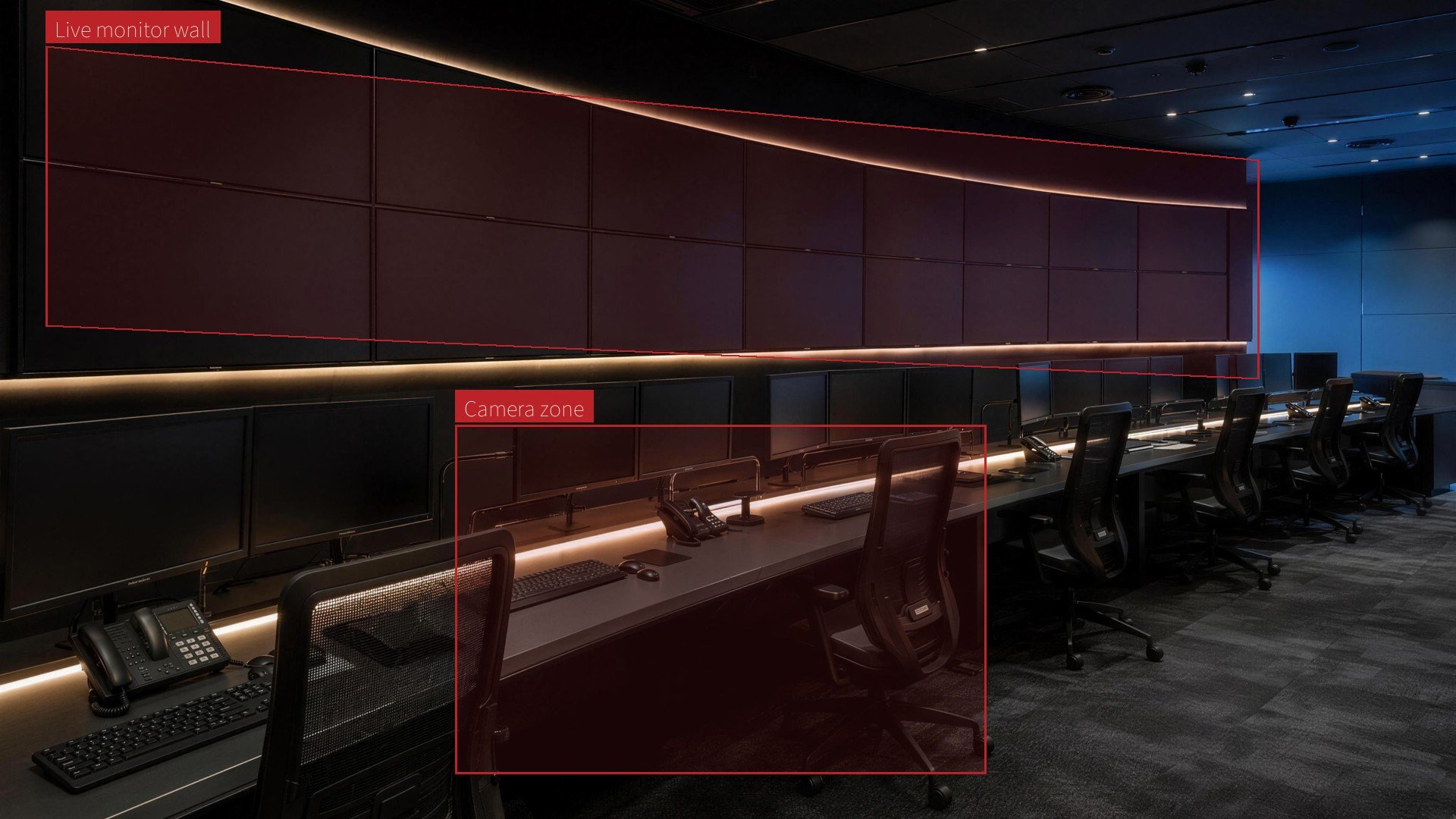 A dark operations room with a curved wall of blank monitors and marked live areas
