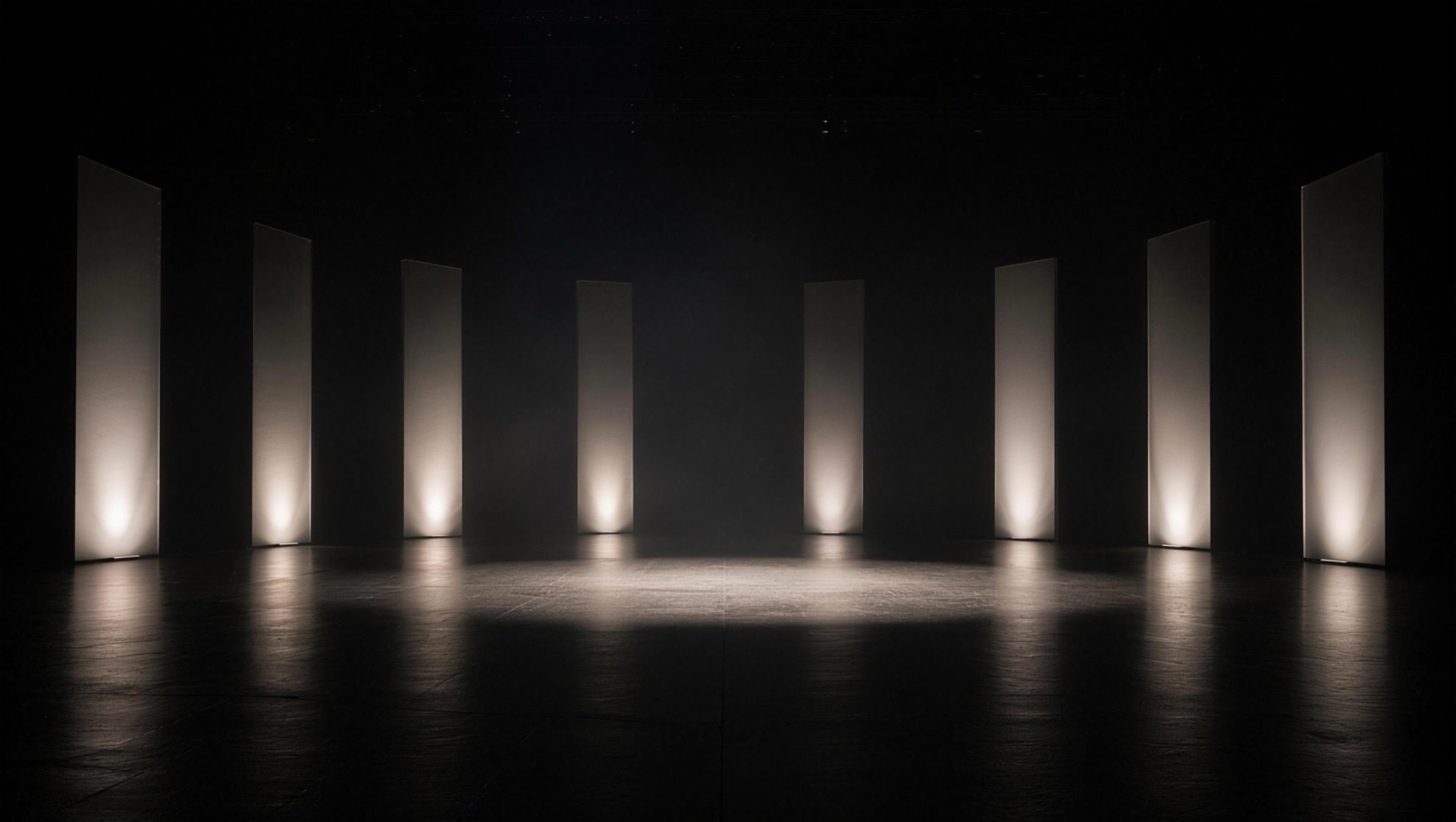 A dark virtual stage with an arc of tall light panels around an open presentation area
