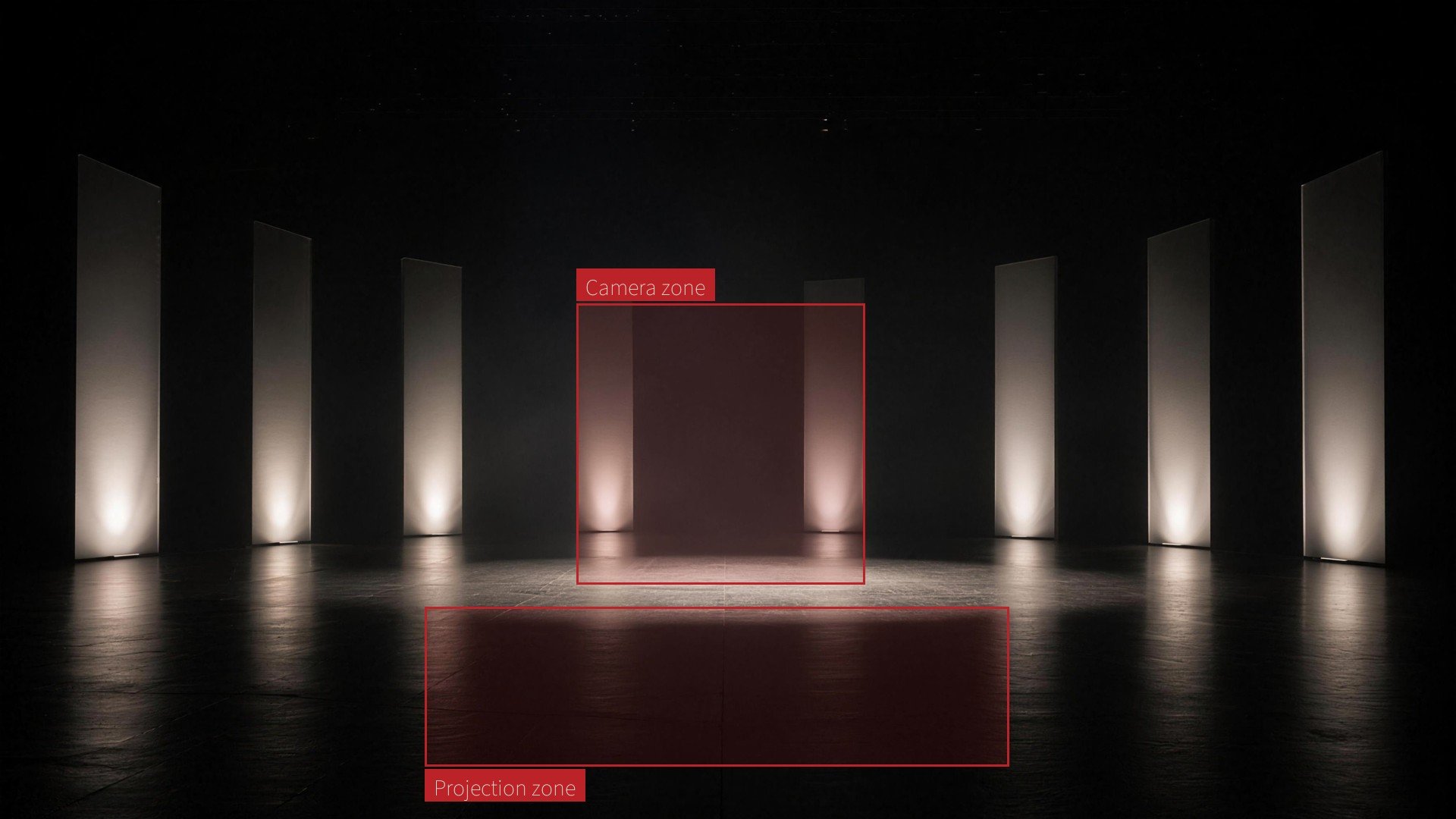 A minimalist dark stage with tall glowing panels and marked live areas